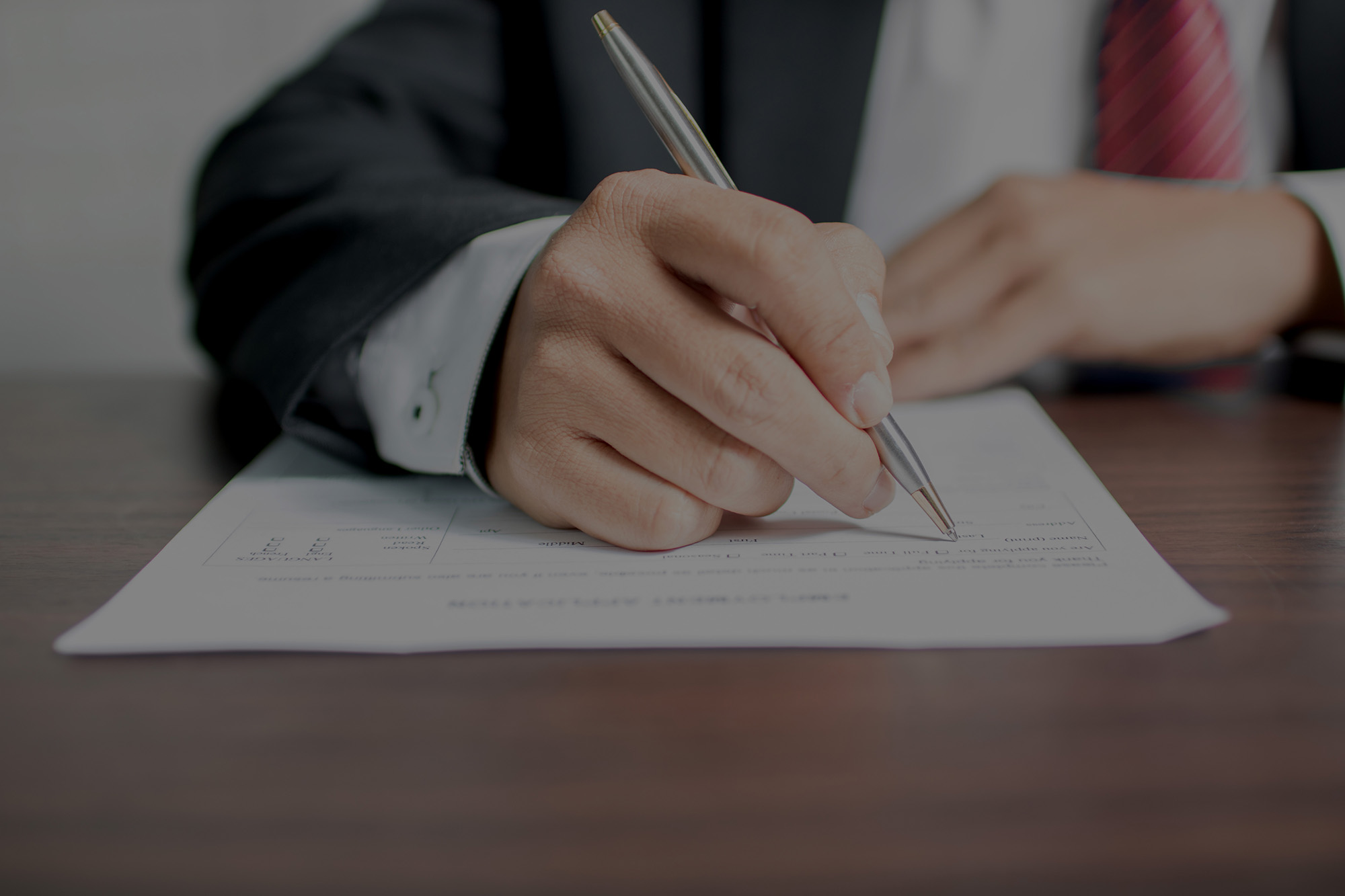 businessman writing on application form